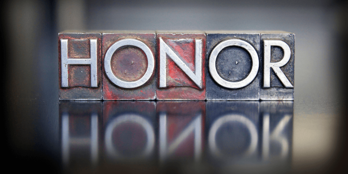 Metal letter blocks spell out the word "HONOR" with a reflective surface beneath them