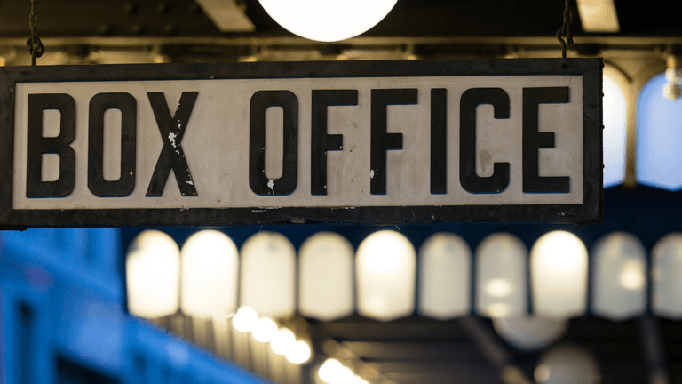 Vintage hanging sign displaying "BOX OFFICE" inside a theater lobby.