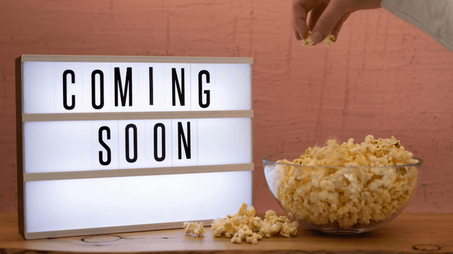 Lightbox displaying "Coming Soon" beside a bowl of popcorn on a wooden table.