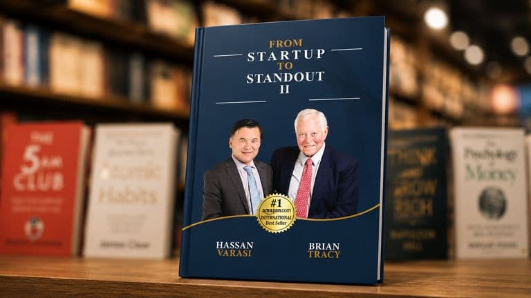 Book cover titled “From Startup to Standout II” featuring Hassan Varasi and Brian Tracy in a bookstore setting.