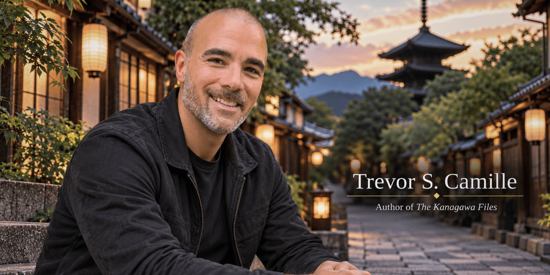 A smiling man sits outdoors in a picturesque traditional setting with lanterns.