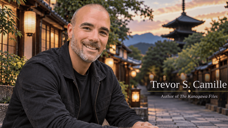 A smiling man sits outdoors in a picturesque traditional setting with lanterns.