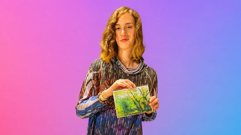 Tomiko Kausal-Hayes holding a framed fine art nature photograph against a colorful backdrop.