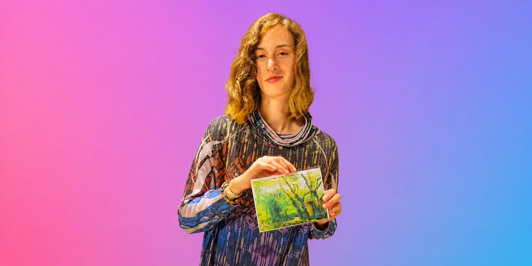 Tomiko Kausal-Hayes holding a framed fine art nature photograph against a colorful backdrop.