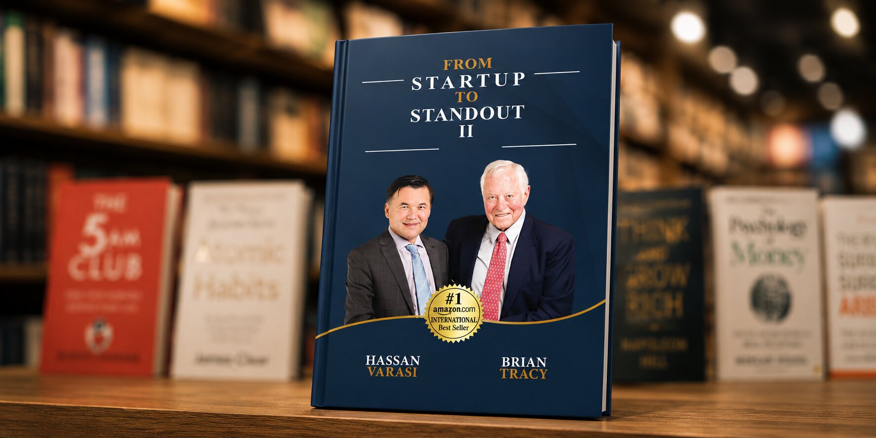 Book cover titled “From Startup to Standout II” featuring Hassan Varasi and Brian Tracy in a bookstore setting.