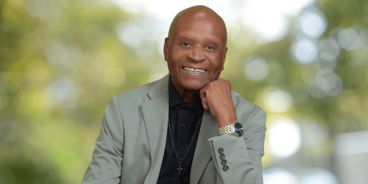 Portrait of Dr. Alvin Haywood smiling in a light gray blazer with a cross necklace.