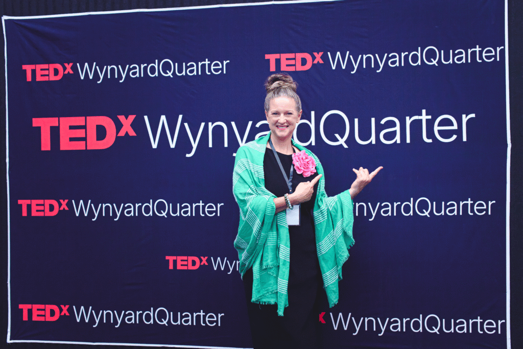 Tina Kapp-Kailea posing in front of the TEDxWynyardQuarter backdrop.